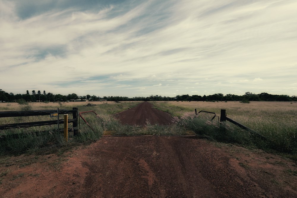 Entrada de tierra a una parcela con portón de madera